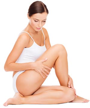 femme en petite tenue se tenant la jambe sur un fond blanc