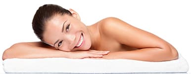 femme blanche et brune souriant allongée sur un lit femme blanche et brune souriant allongée sur un lit