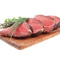 Morceaux de viande sur une planche à découper avec des feuilles sur un fond blanc. Morceaux de viande sur une planche à découper avec des feuilles sur un fond blanc.