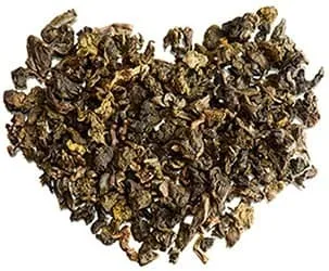 tas de thé seché marron formant un coeur sur un fond blanc