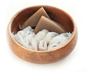 bol en bois contenant des nouilles de konjac sur un fond blanc