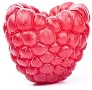 framboise rose prise en gros plan avec une forme de coeur sur fond blanc