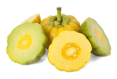 plusieurs fruits garcinia cambogia découpés en morceaux sur un fond blanc