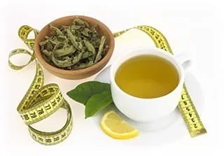 tasse de thé vert avec un bol rempli de feuilles de thé sur fond blanc