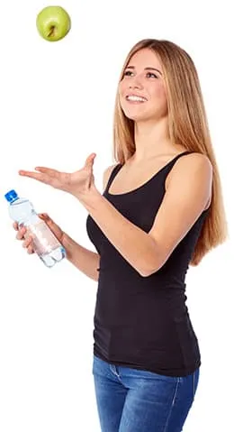 femme blanche lancant une pomme verte e l'air avec une bouteille d'eau