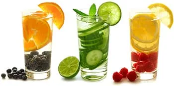 trois grand verres rempli de fruits avec de l'eau sur un fond blanc