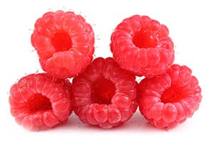 plusieurs framboises rouges entassées sur un fond blanc