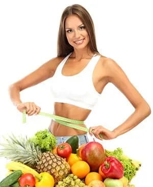 femme en tenue de sport et un tas de fruits multicolores