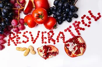 resveratrol ecrit avec des fruits multicolores sur un fodn blanc