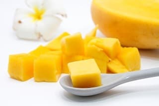 mangue découpée en dés dans une petite cuillere sur une table