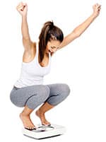 femme en tenue de sport accroupi sur une balance - weightworld femme en tenue de sport accroupi sur une balance - weightworld