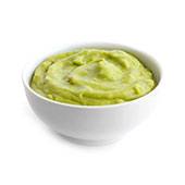 Bol blanc de chlorella en poudre mélangée à du guacamole vert