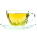 tasse remplie de thé vert sur une assiette transparente