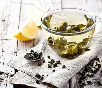 thé verts infusé avec tranches de citron sur une table