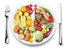 assiette de fruits et legumes accompagnée d'une fourchette et d'un couteau