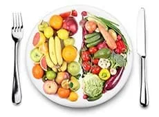 assiette de fruits et legumes accompagnée d'une fourchette et d'un couteau