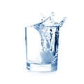 Coupe en verre avec de la glace et de l'eau en mouvement sur un fond blanc Coupe en verre avec de la glace et de l'eau en mouvement sur un fond blanc