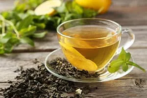 tasse de thé vert avec des feuilles de thé fraiches