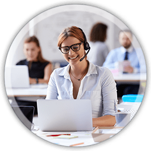 office woman at a desk working weaaring a headset smiling