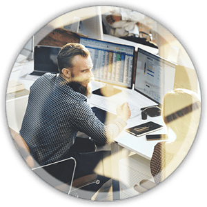circle img 2 man sitting at a desk working on a computer with multiple screens