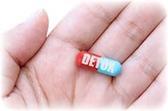 gelule detox rouge et bleu dans une main sur un fond blanc gelule detox rouge et bleu dans une main sur un fond blanc