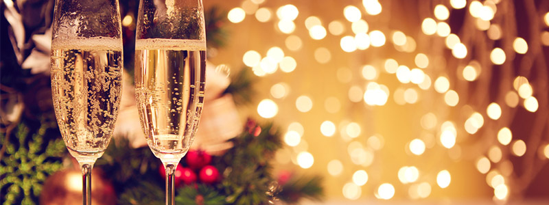 deux verres de champagne devant les lumières de Noël